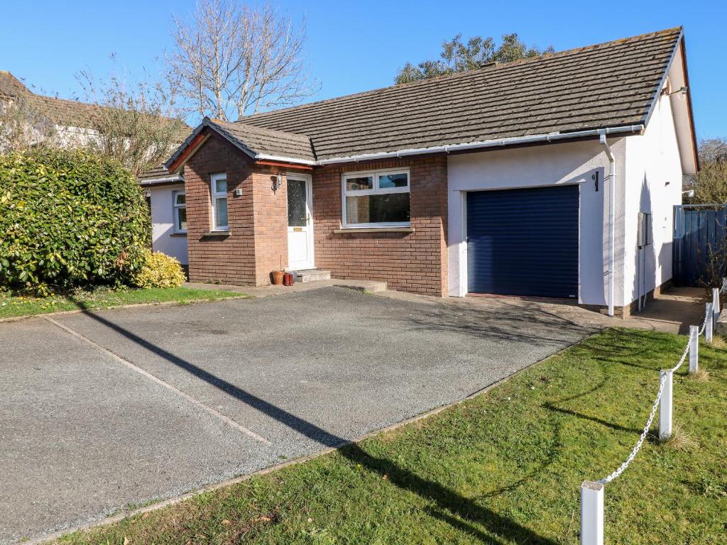 a brick house with a garage and a driveway at 1 Gloucester Way in Pembroke Dock