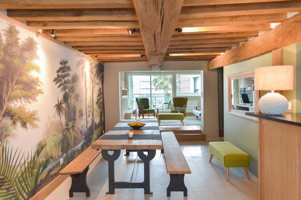 comedor con mesa de madera y sillas en La Maison de Pierre et Valérie St Leonard Honfleur, en Honfleur