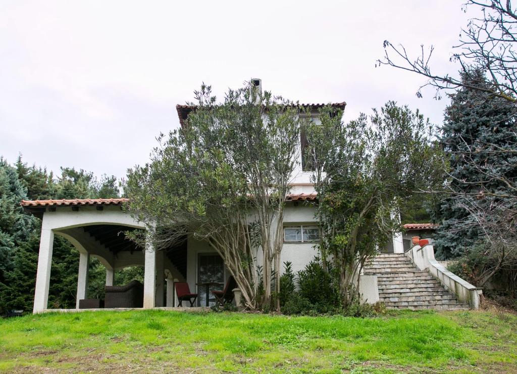 a white house with a porch and some trees at Luxury Chez-Moi in Serres