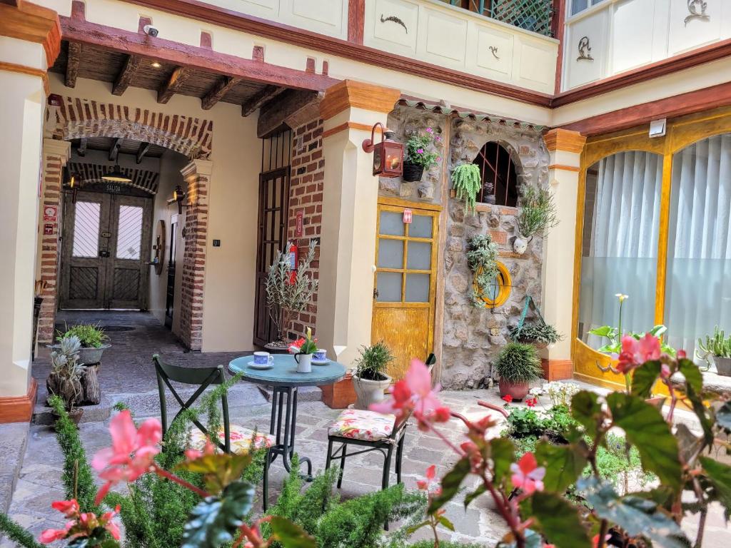 a patio with a table and chairs and flowers at Old Town Quito Suites, Heritage Boutique Hotel, Where Every Detail Tells a Story in Quito