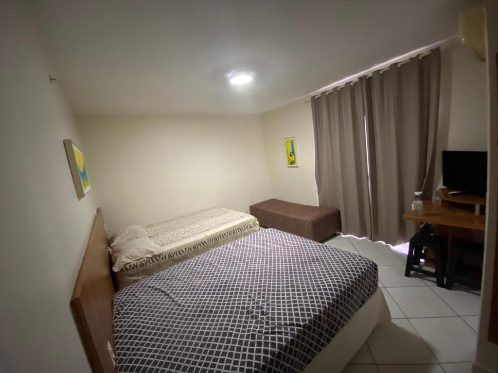 Habitación pequeña con cama y escritorio. en Locação Caldas Novas 1211, en Caldas Novas