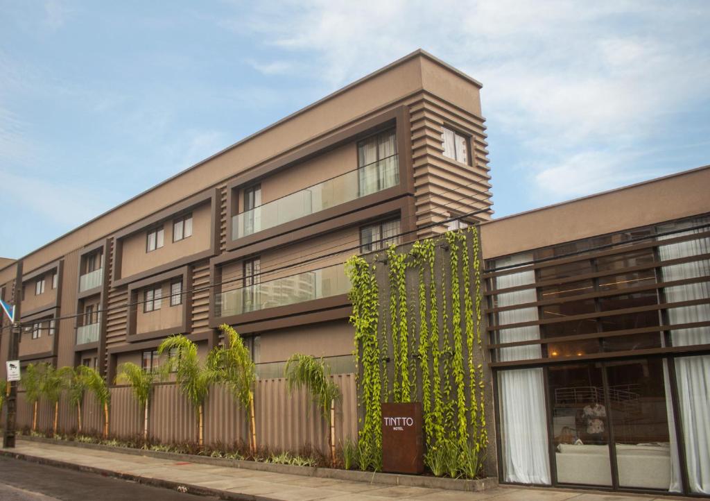 um edifício com plantas ao lado dele em Tintto Hotel em Fortaleza