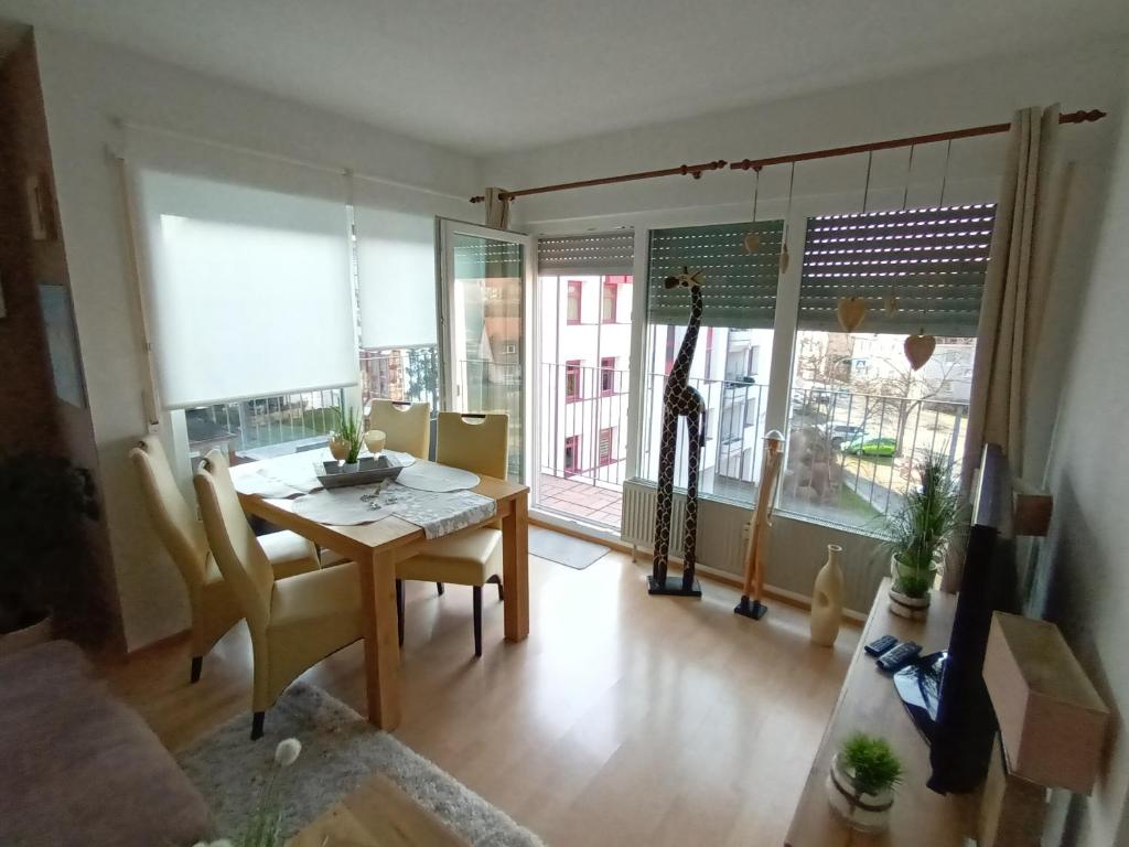 a living room with a dining room table and a giraffe in the window at Wie Daheim in Nuremberg