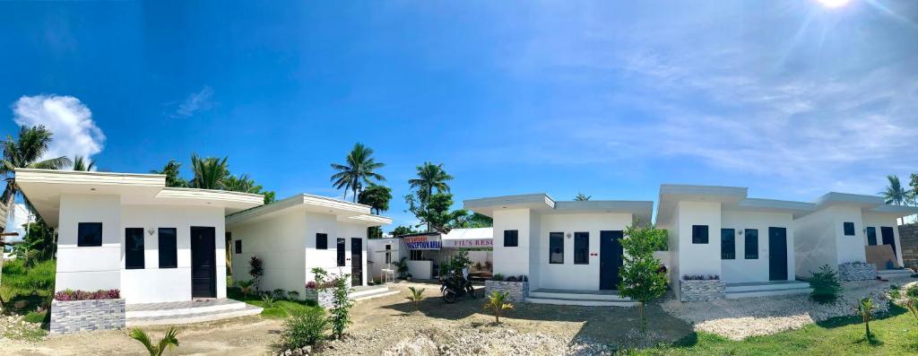 duży biały dom z palmami w tle w obiekcie Fil's Resort w mieście Moalboal
