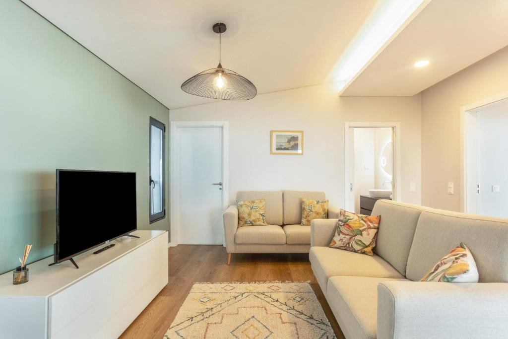 ein Wohnzimmer mit Sofa und Fernseher in der Unterkunft Referta House in Prazeres