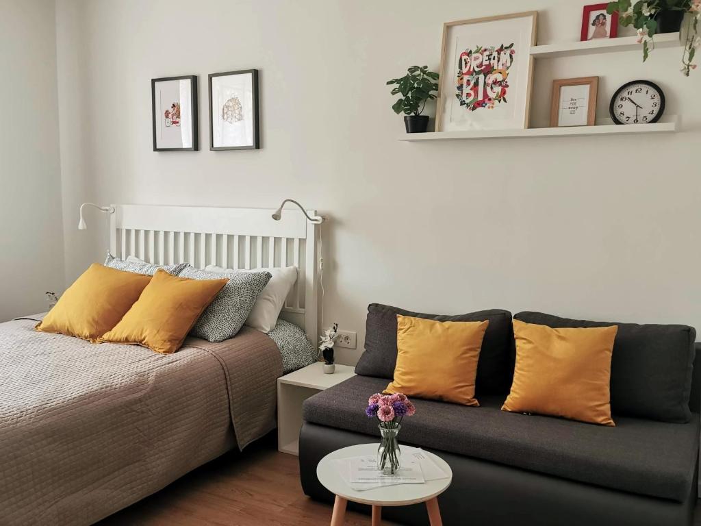 uma sala de estar com uma cama e um sofá em Studio apartman Mirta em Varaždin