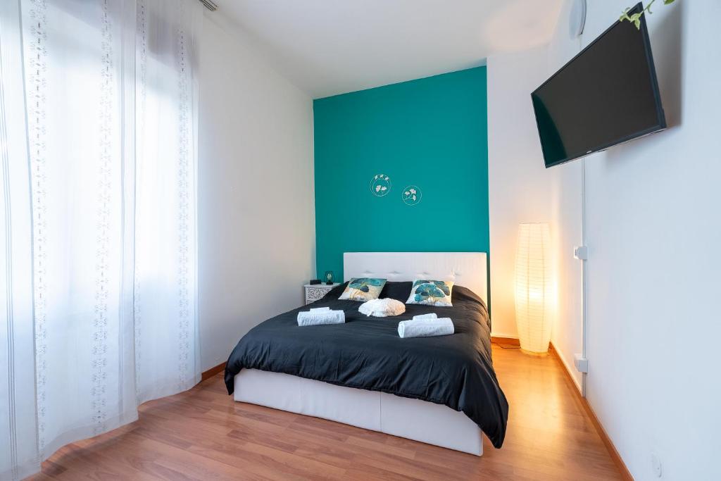 1 dormitorio con 1 cama con pared azul en San Siro Big House Wifi Netflix Free Parking, en Milán
