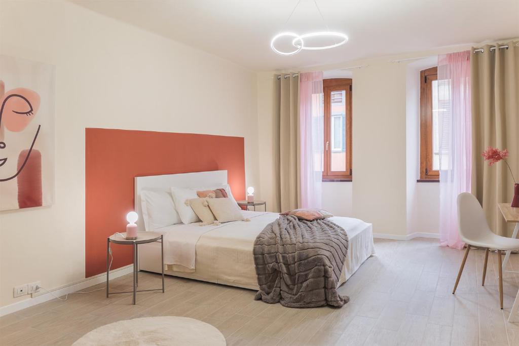 1 Schlafzimmer mit einem Bett sowie 2 Tischen und Stühlen in der Unterkunft DOMUSBERGAMO - Boutique Apartment in Bergamo