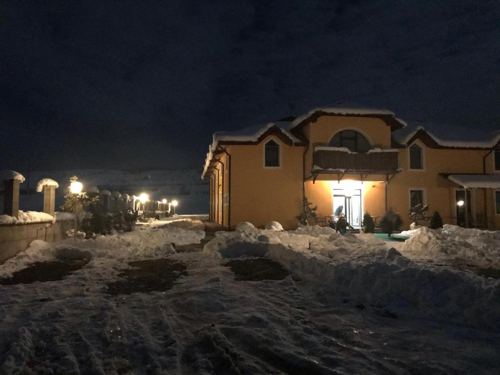 a house is covered in snow at night at SOLL in Lugoj