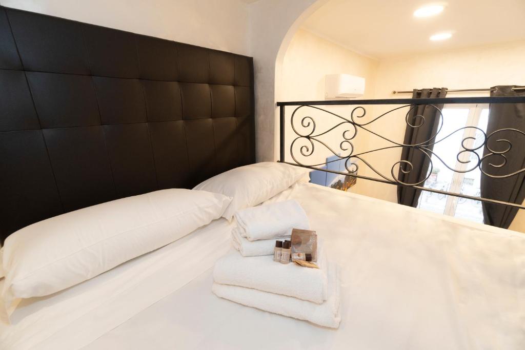 a bed with white pillows and a black headboard at POPOLO PEN 56 Apartament in Rome
