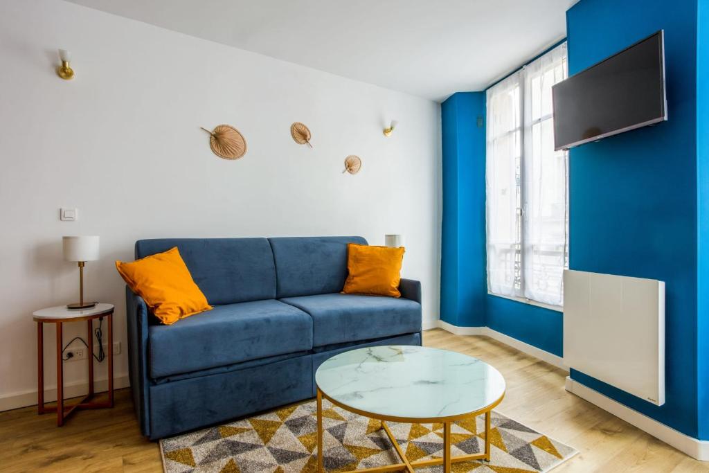 een woonkamer met een blauwe bank en een tafel bij Superb studio just nearby the Versailles palace - Welkeys in Versailles