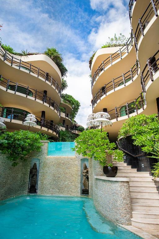 a hotel with a swimming pool in front of a building at El Taj Oceanfront and Beachside Condo Hotel in Playa del Carmen