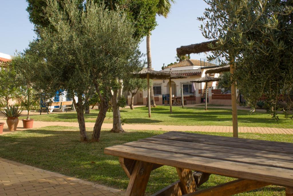a wooden picnic table in a park with a house at Apartamentos Bellavista Bolonia in Bolonia