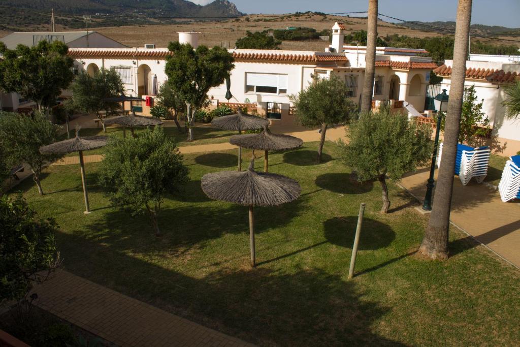 a group of umbrellas in a park in front of a building at Apartamentos Bellavista Bolonia in Bolonia
