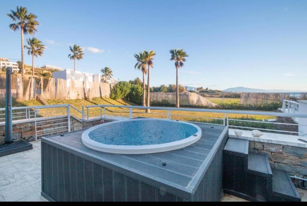 einen großen Pool auf einer Terrasse mit Palmen in der Unterkunft Casares del Mar Luxury Apartment in Málaga
