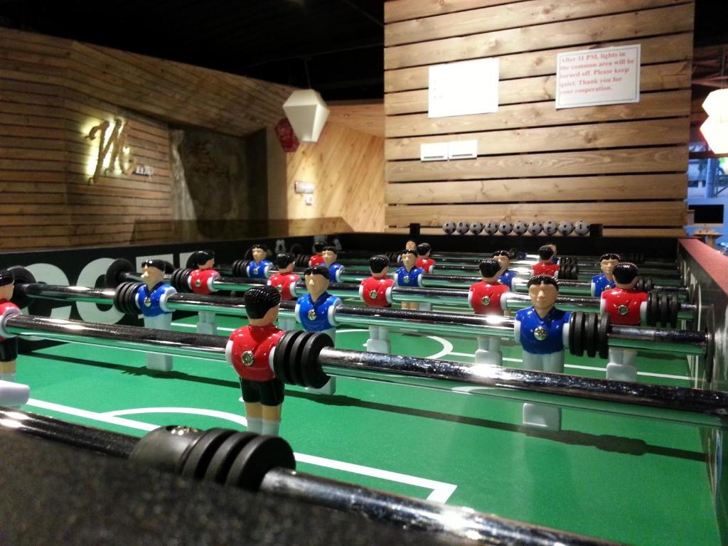 a group of people playing a game of billiard at Meander Taipei Hostel - Ximending in Taipei