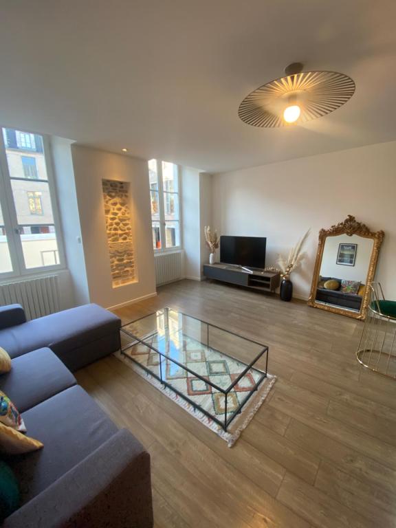 uma sala de estar com um sofá e uma mesa de vidro em Quartier historique - Parking - Idéal Couple em Pau