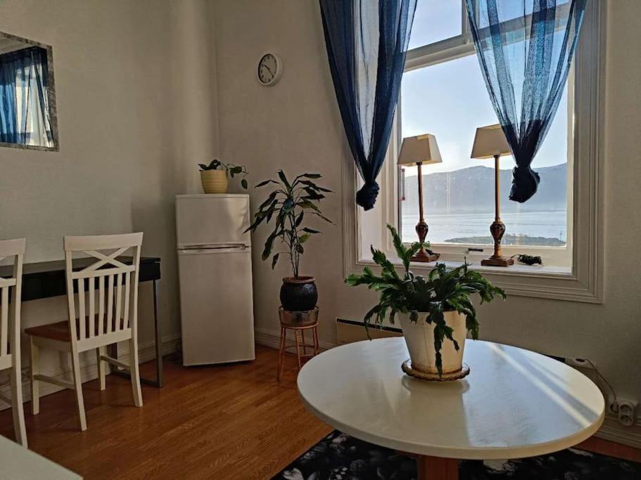 a living room with a table and a large window at Cozy, Central, Ocean View in Ålesund