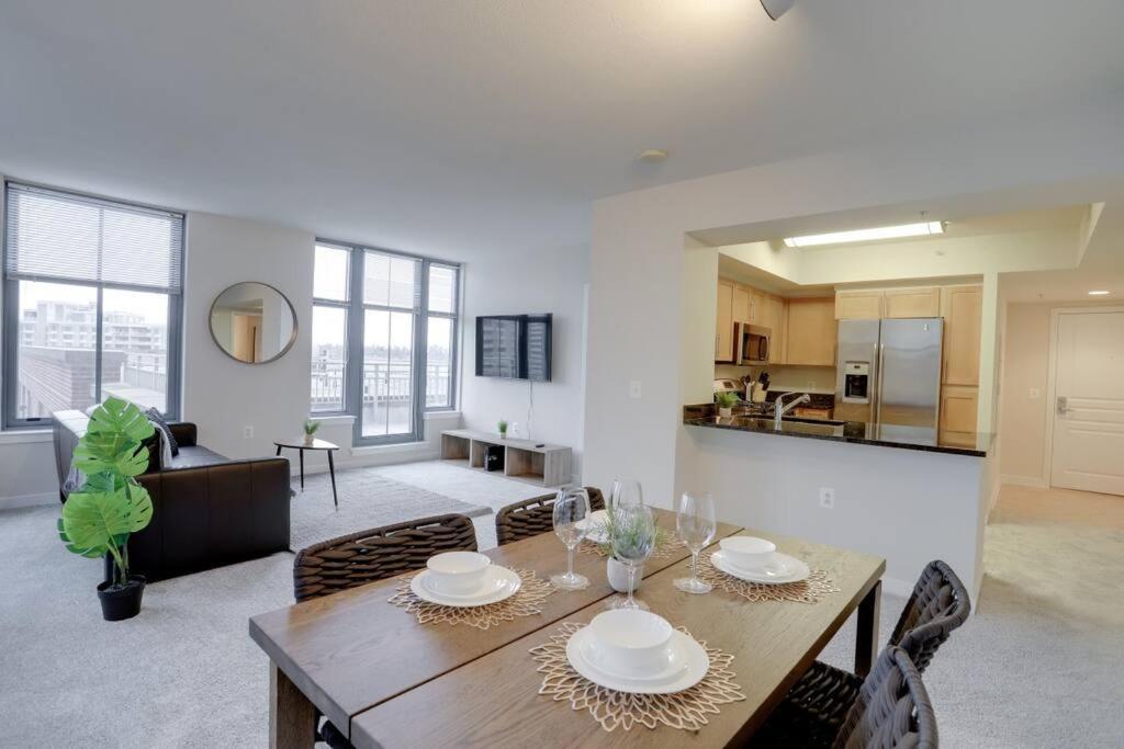 a dining room and living room with a table and chairs at Wonderful 2 BR Condo At Pentagon City with Gym in Arlington