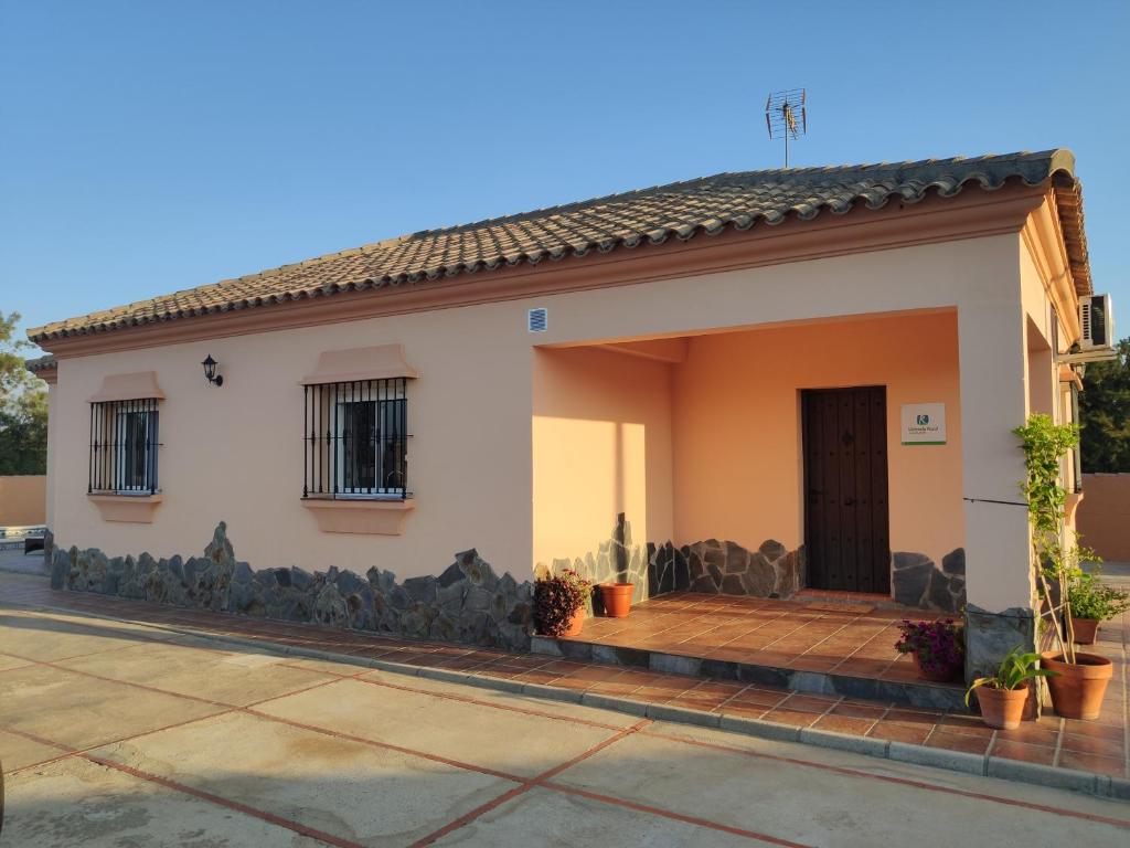 ein kleines weißes Haus mit einer Holzveranda in der Unterkunft Casa Rural Asgard in Chiclana de la Frontera