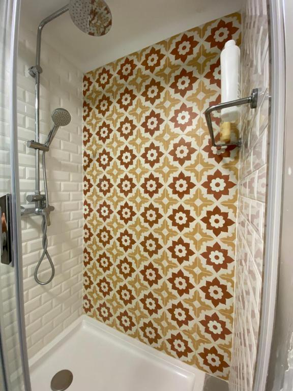 a bathroom with a shower and a tile wall at Cozy Estrela Apartment in Lisbon