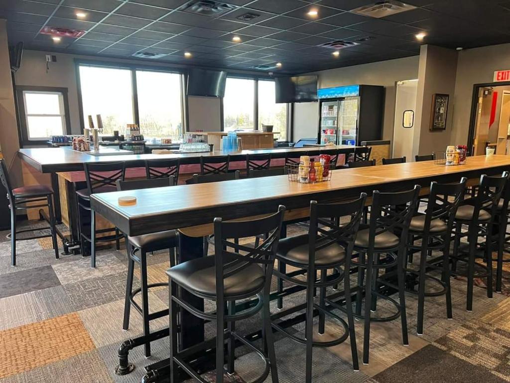 um restaurante com um grande bar de madeira com bancos pretos em Salt Creek Golf Retreat em Nashville