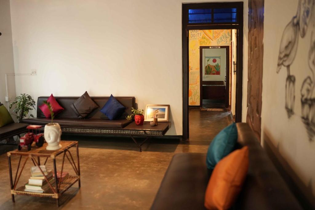 uma sala de estar com um sofá e uma mesa em Zebra Hostels em Varkala