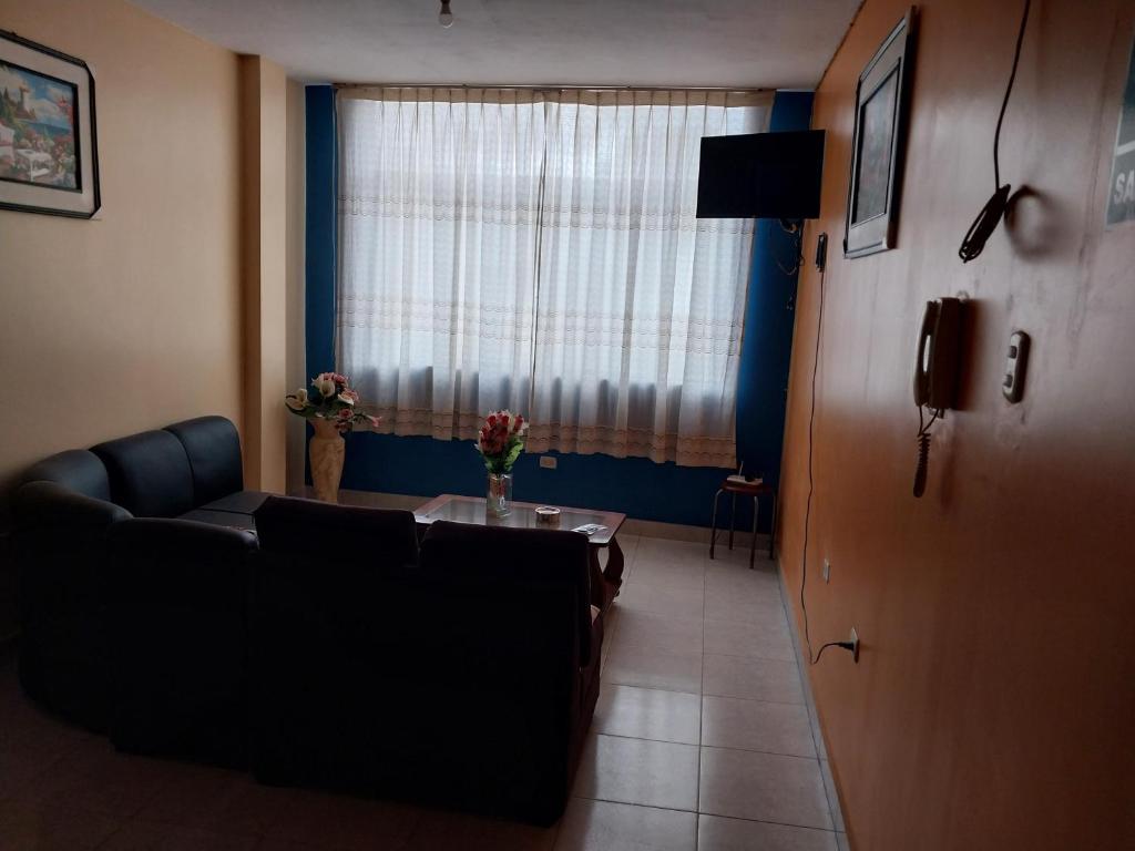 sala de estar con sofá, mesa y ventana en ALOJAMIENTO EDUCOL, en Moyobamba