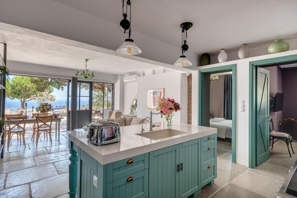 a kitchen with a sink and a table with chairs at Alma Loca Syros in Ermoupoli