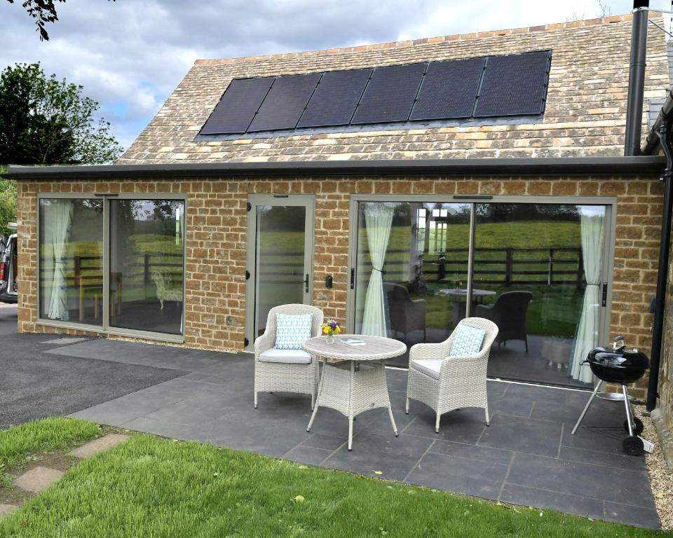 a patio with a table and chairs with solar panels at The Tack Room at Castle Chase Ayston 