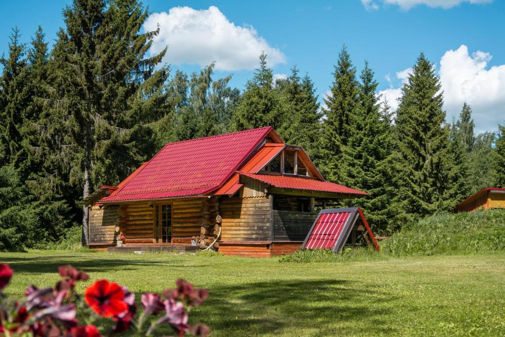 une cabane en rondins avec un toit rouge dans l'établissement Väike Kuu peamaja, à Myza Kastre