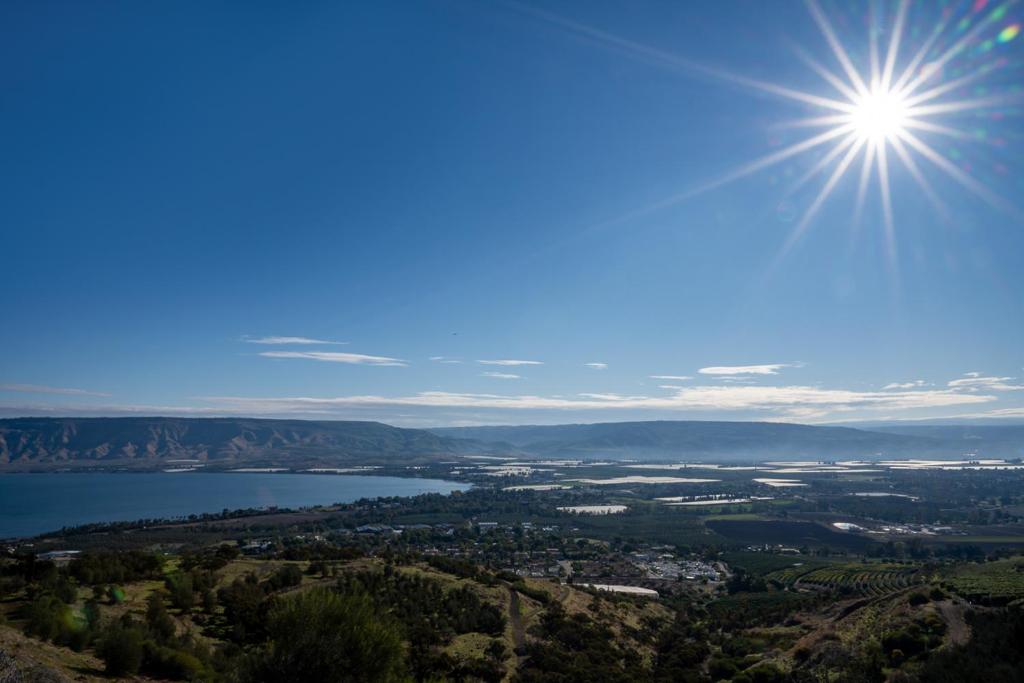 a view of a lake with the sun in the sky at Jacob Ohalo Kinneret in Kinneret