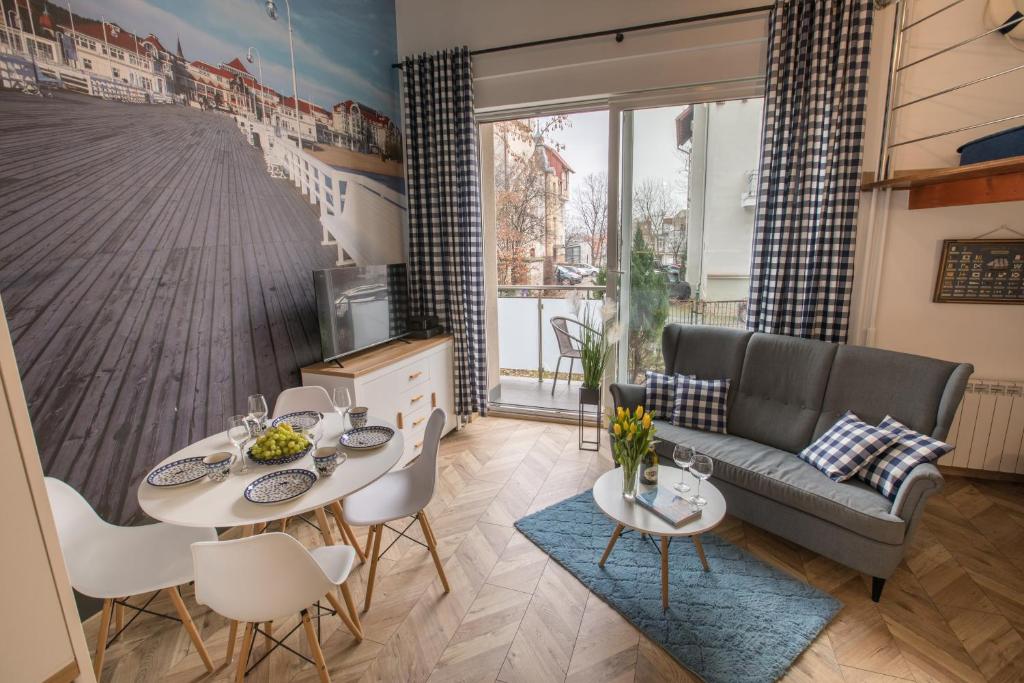 a living room with a couch and a table and chairs at Apartament Chopina 5 m5 - Centrum Sopotu 3 min do Monciaka in Sopot