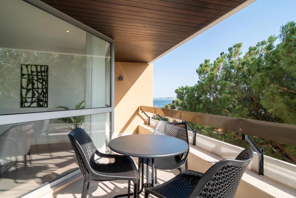 a patio with chairs and a table on a balcony at Coastal Charm by LovelyStay in Oeiras