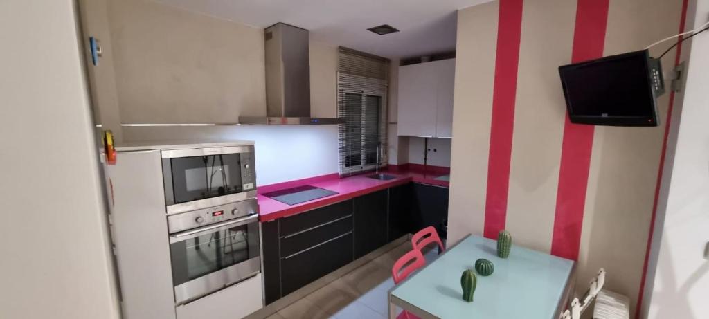 małą kuchnię z czerwono-białą ścianą o paskach w obiekcie LA CASITA DE LA PUERTA DE CARMONA w Sewilli