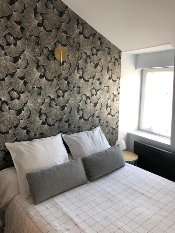 a bedroom with a bed with a floral accent wall at Saint Bonnet in Bourges