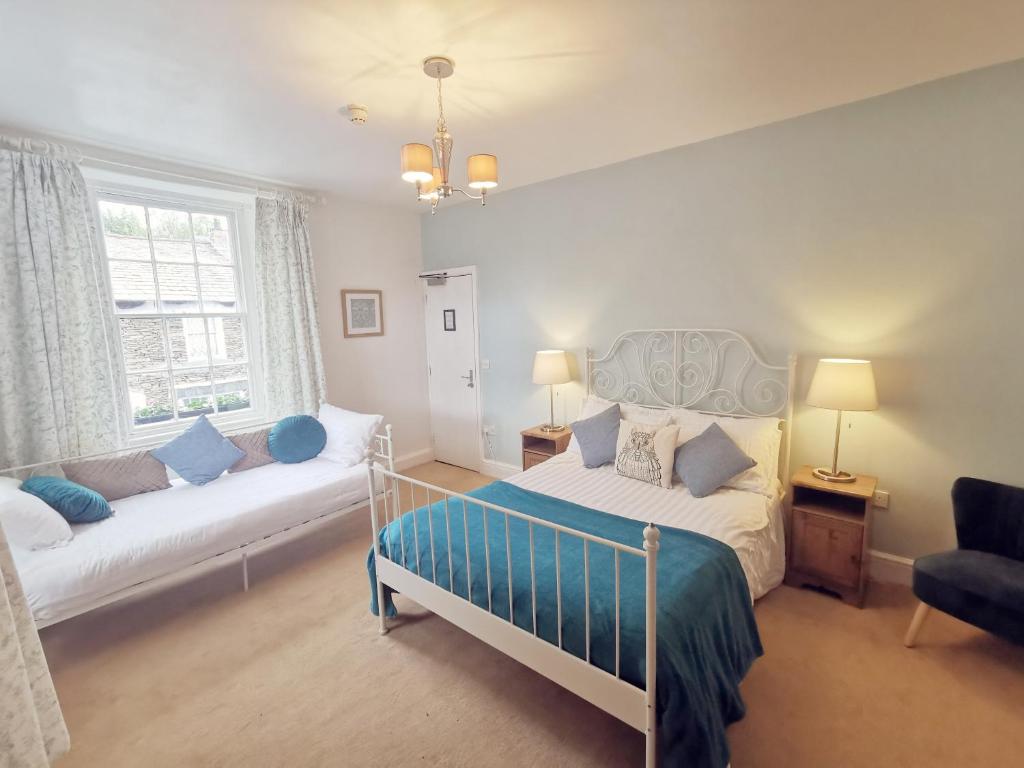 - une chambre avec un lit et un canapé dans l'établissement The Elleray, à Windermere