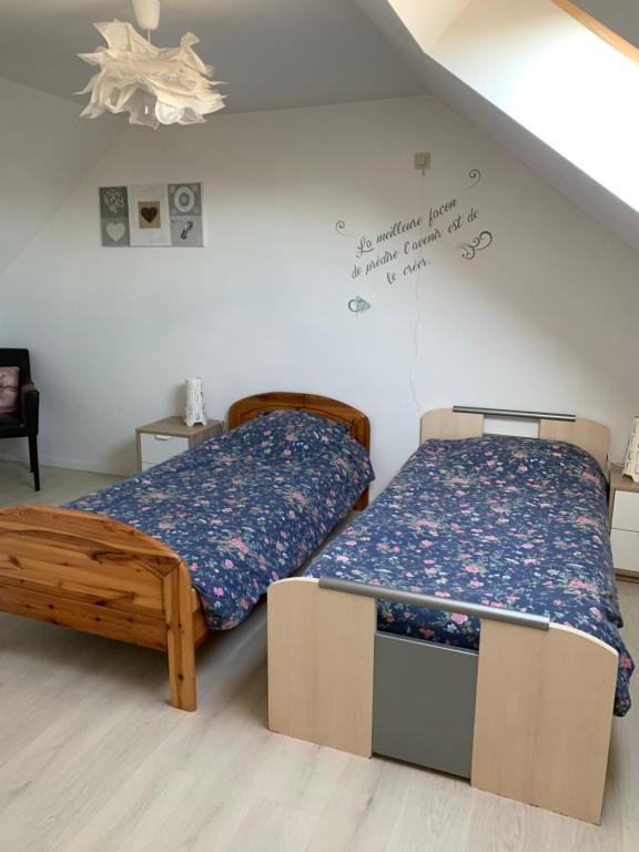 two beds in a small room with a bedskirts at Carpe Diem in Jumet