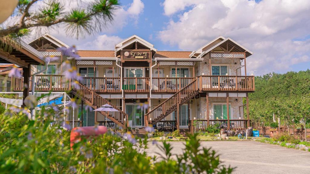 a large house with balconies and a deck at Tinkerbell Pension in Gyeongju