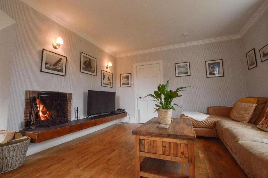 a living room with a couch and a fireplace at Cologin Farmhouse in Oban