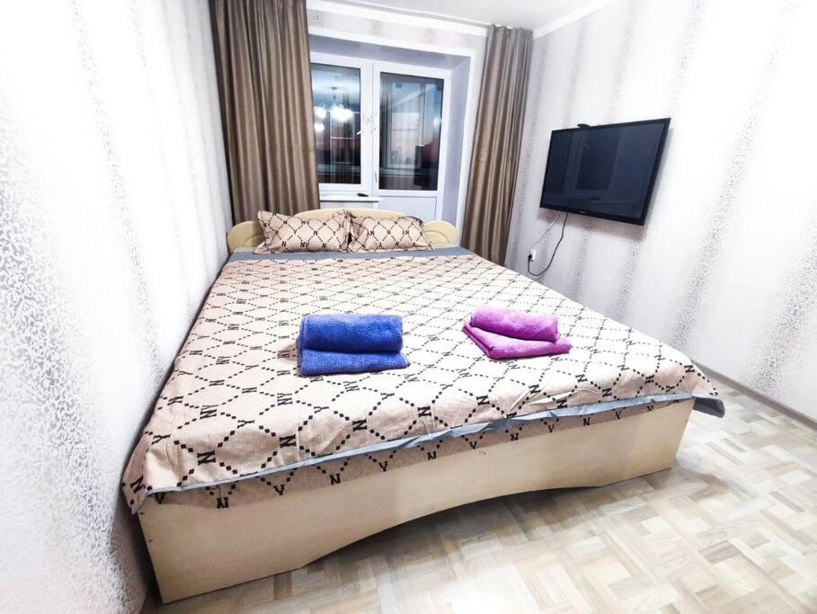 Un pat sau paturi într-o cameră la Уютные апартаменты прям в центре города