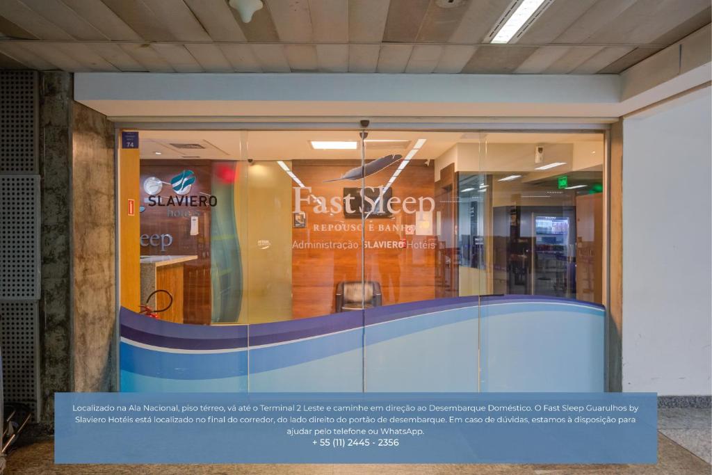 a glass window in a building with a sign on it at FAST SLEEP Guarulhos by Slaviero Hotéis in Guarulhos