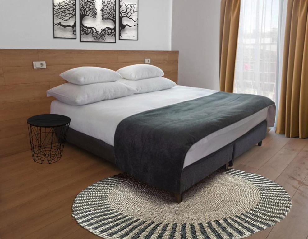 um quarto com uma cama grande com lençóis brancos e almofadas em BG Exclusive Suites em Belgrado