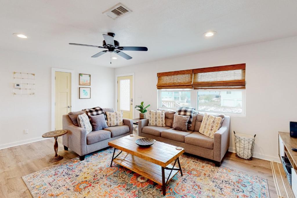 uma sala de estar com dois sofás e uma mesa em The Beach Sunflower em Pensacola Beach