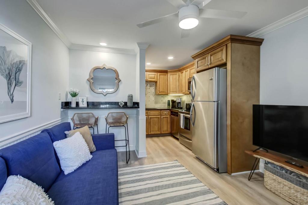 a living room with a blue couch and a kitchen at Sea La Vie in Tybee Island