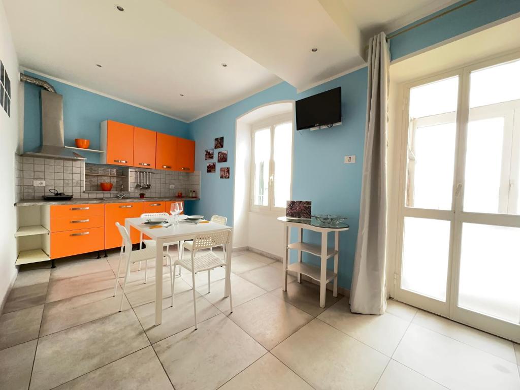 een keuken met oranje kasten en een tafel en stoelen bij Appartamenti a Cà Mia in La Spezia