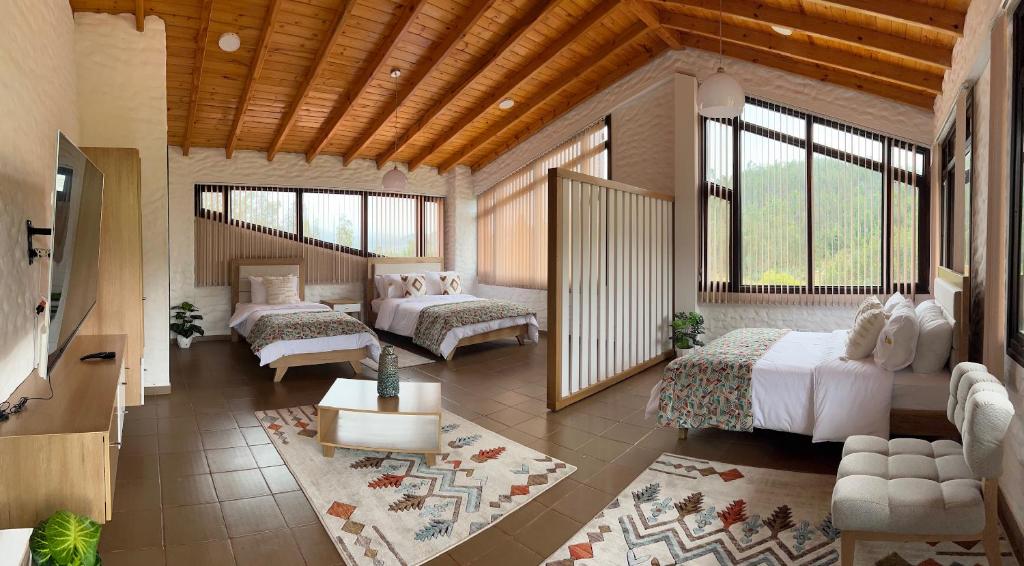 Cet appartement comprend une chambre avec deux lits et un salon avec des fenêtres. dans l'établissement Villa Germana, à Paipa