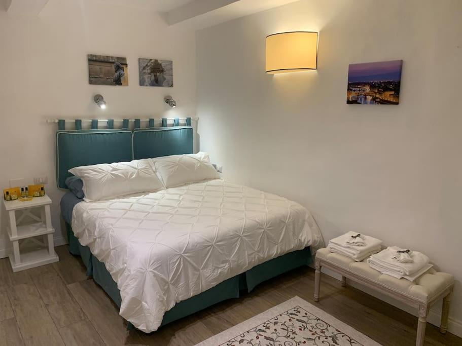 Schlafzimmer mit einem Bett mit einem grünen Kopfteil in der Unterkunft Bilocale nel cuore di Firenze in Florenz