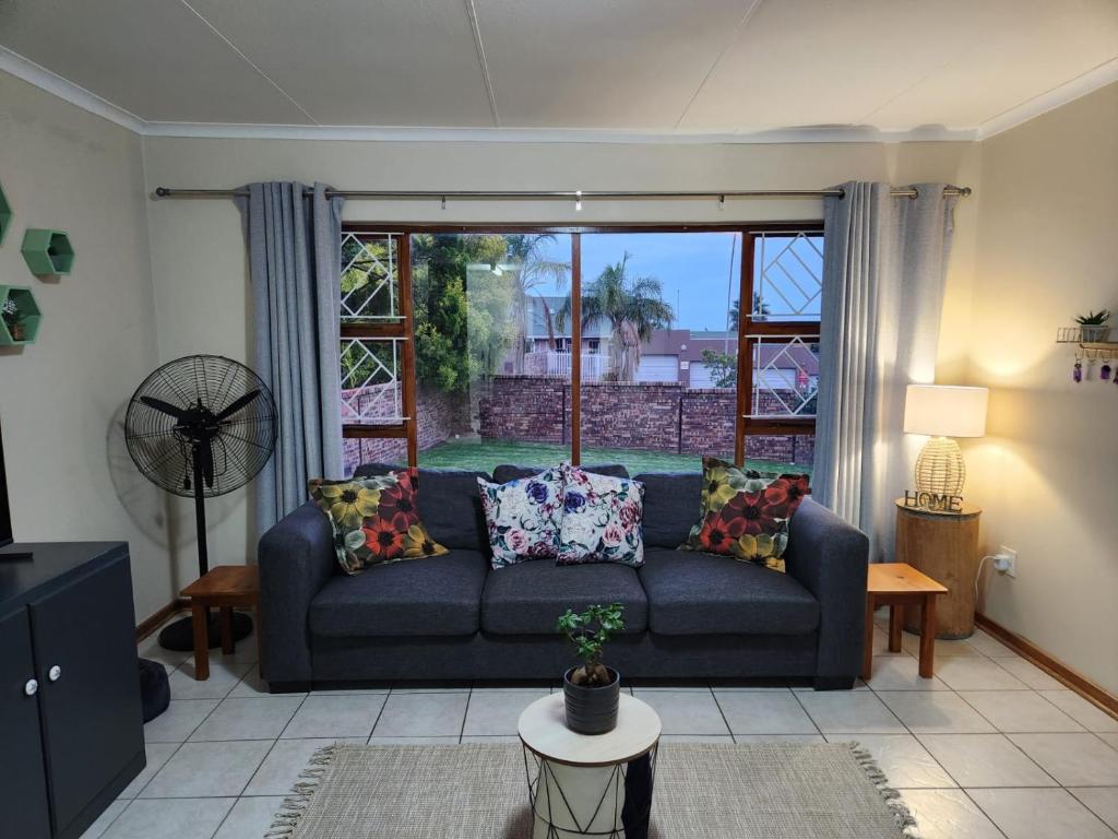 Bloemfontein的住宿－Habitat Place，客厅设有蓝色的沙发和窗户。