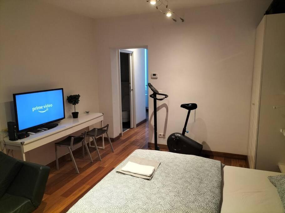 ein Wohnzimmer mit einem TV und einem Tisch mit Stühlen in der Unterkunft Appartement - Quartier européen in Brüssel